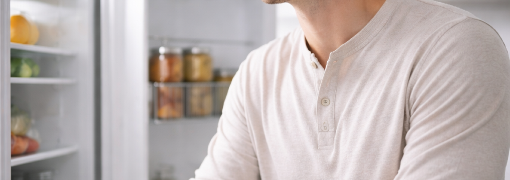 Hombre pensativo frente al frigorífico